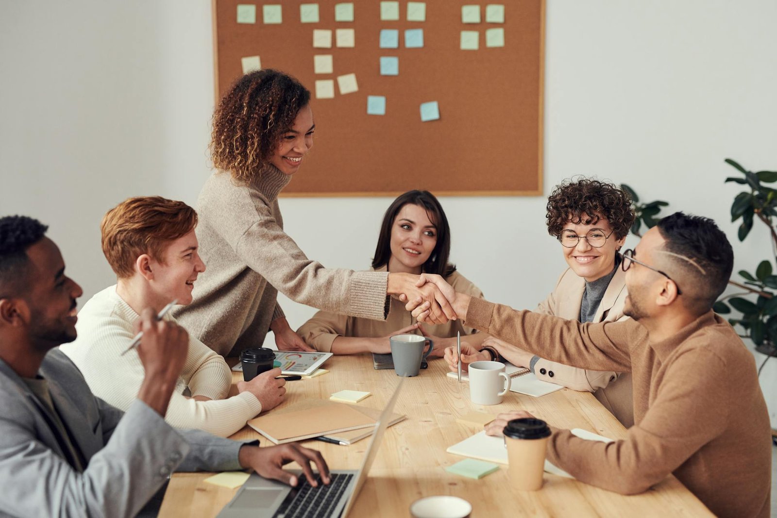 Diverse business professionals shaking hands in a modern office setting, representing partnership and trust in Kenya business operations
